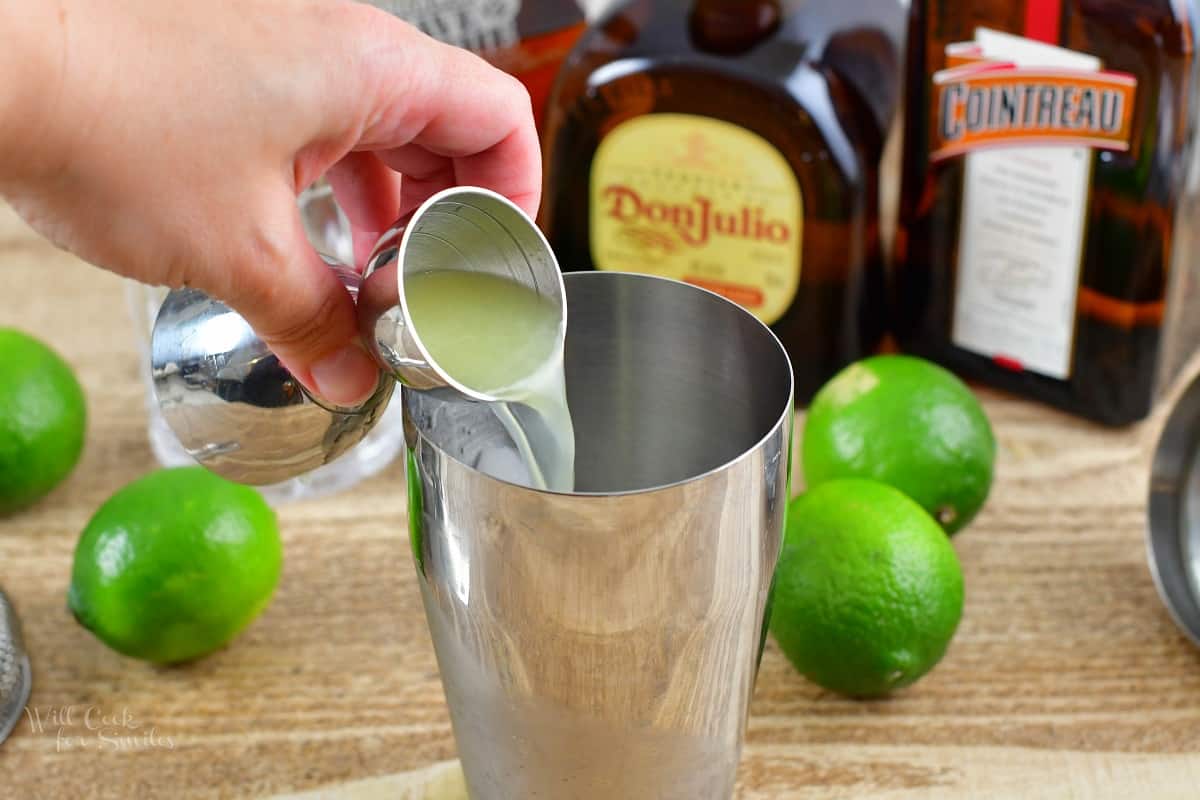 pouring in lime juice into the cocktail shaker