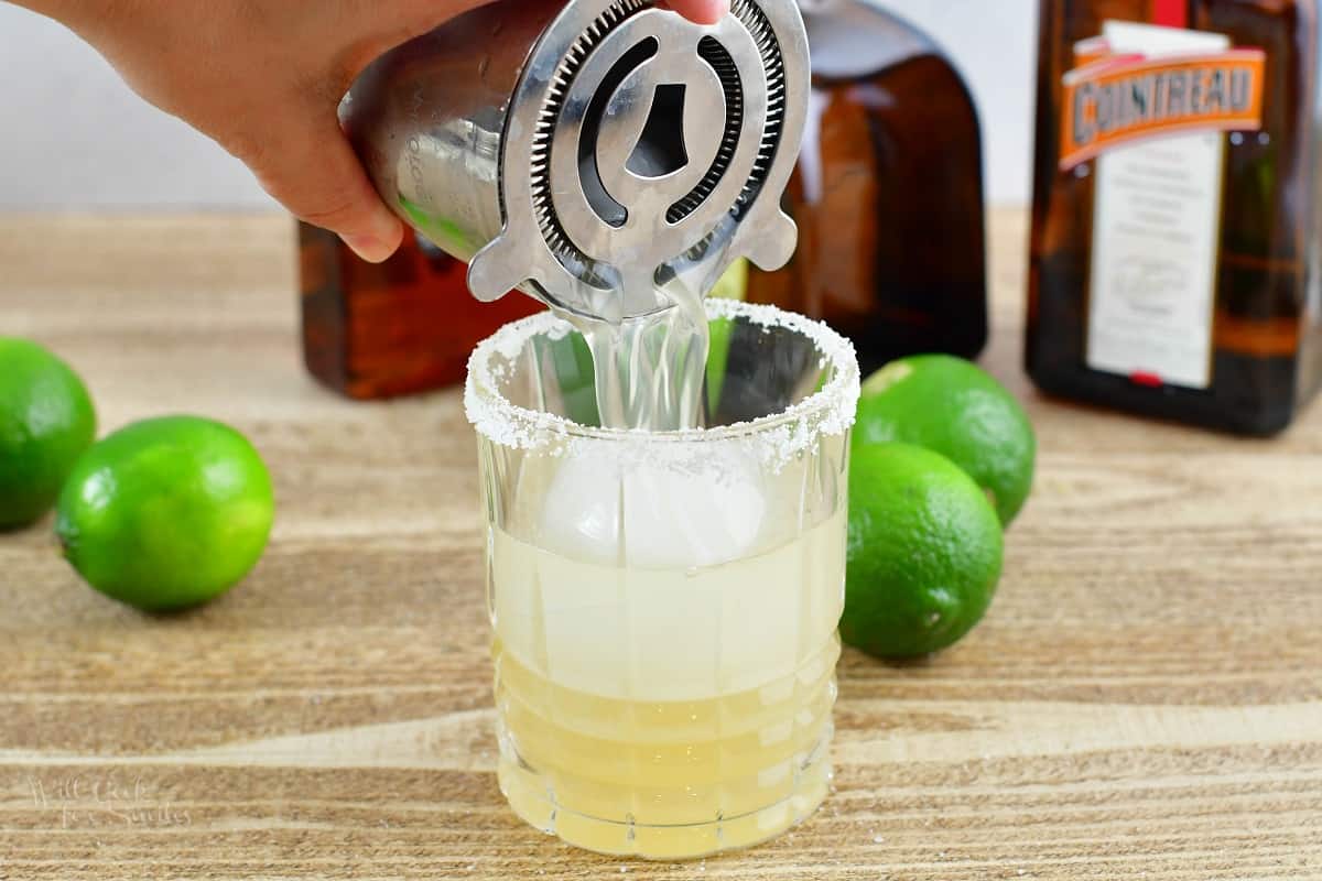 pouring the light cocktail into the glass