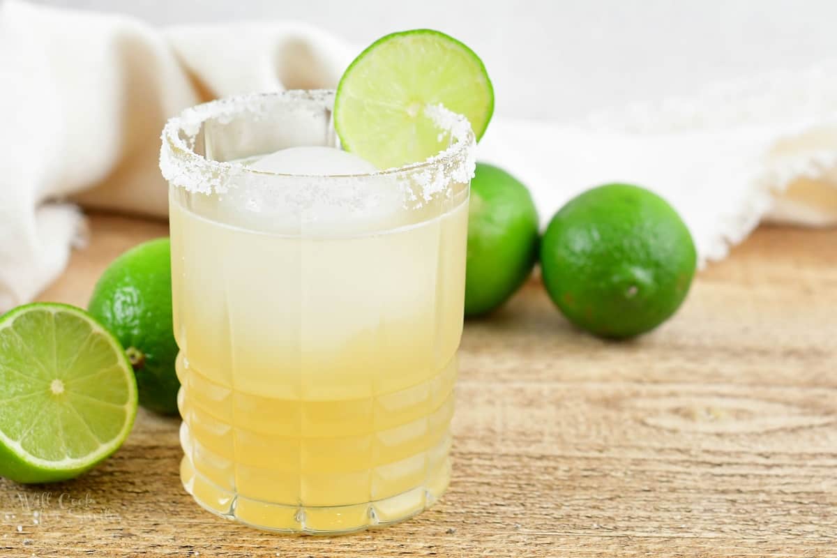 close-up of margarita in a glass with salt and limes around