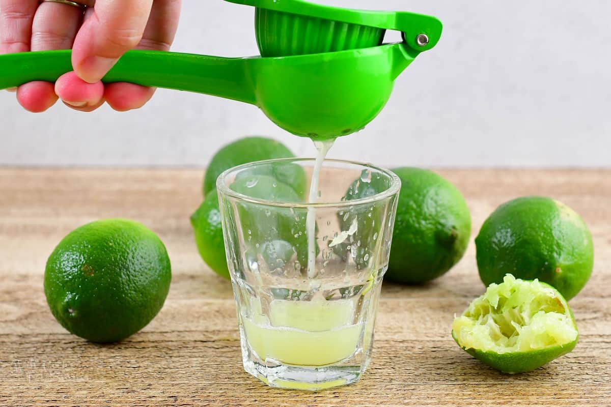 squeezing the lime juice out of the lime in juicer