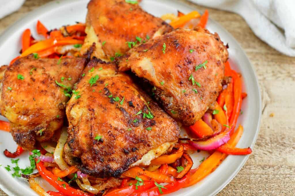 cooked chicken thighs with bell peppers and onions