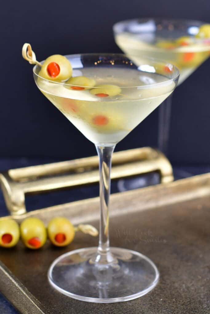 side view of the martini in a tall glass with olives