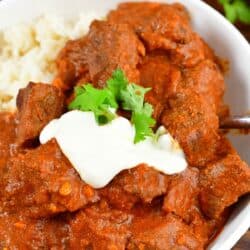 spooning out some lamb Rogan Josh from the bowl