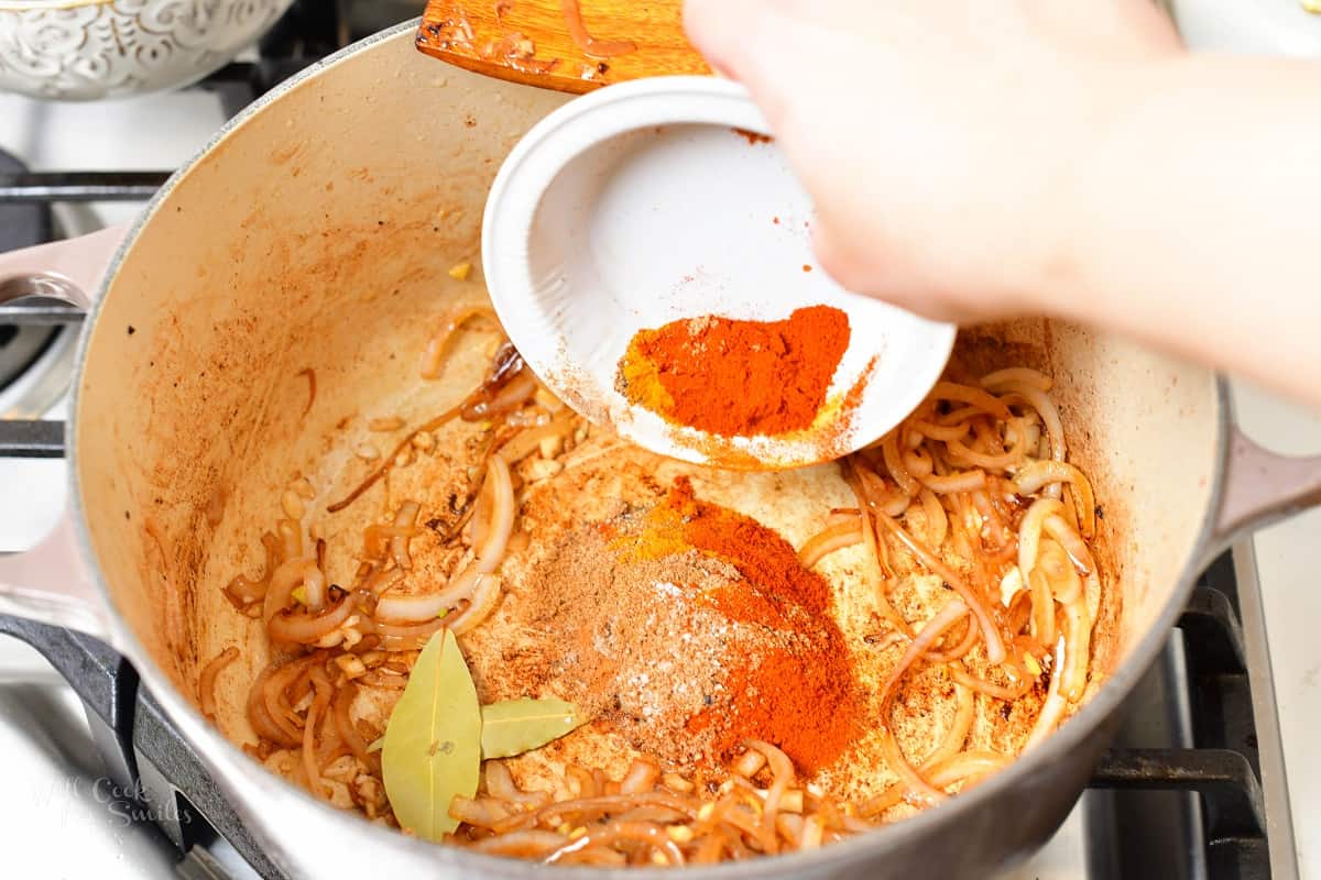 adding spices to the Dutch oven with onions