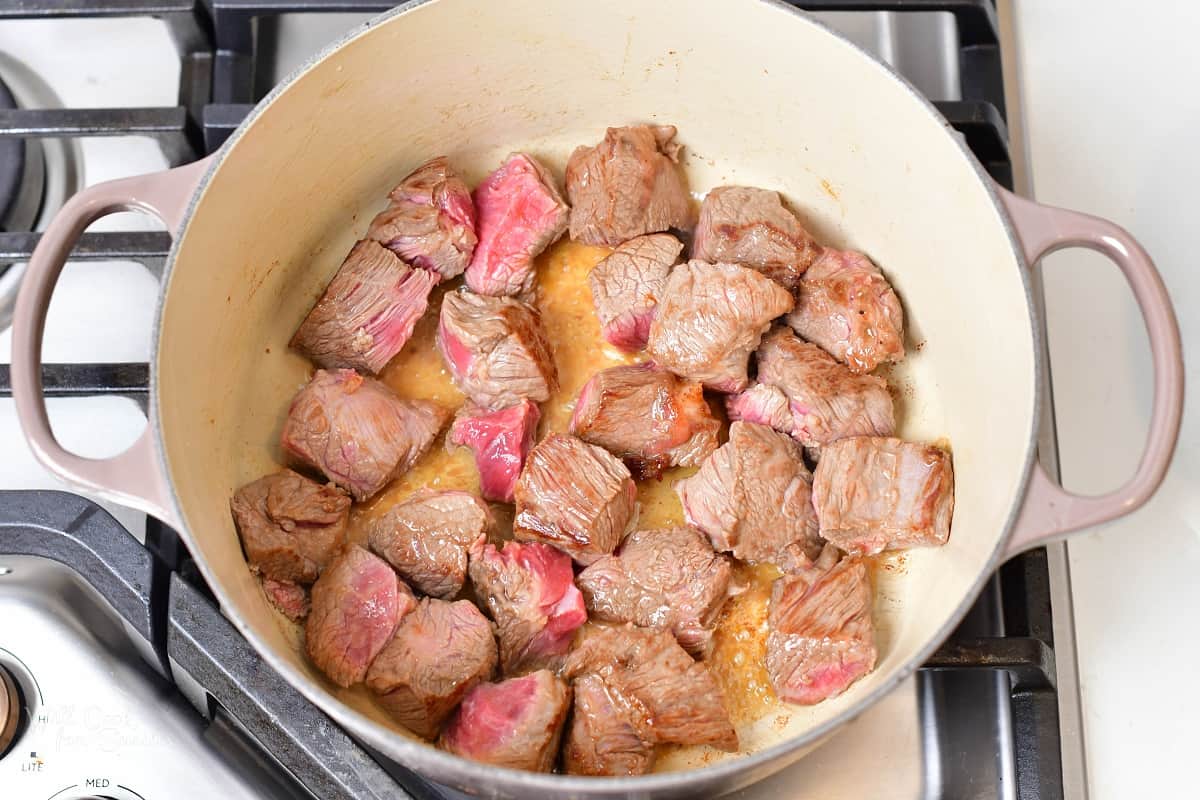 lamb pieces searing in a Dutch oven