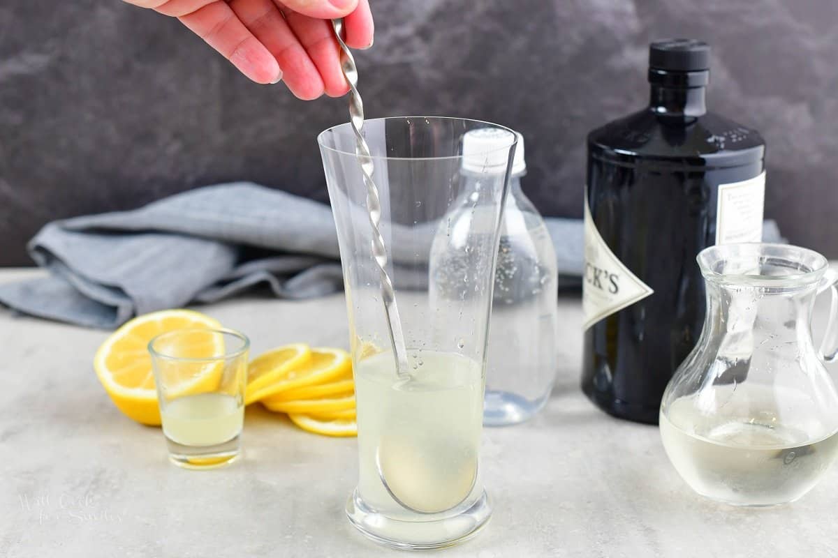 stirring the lemon juice and gin together in a glass