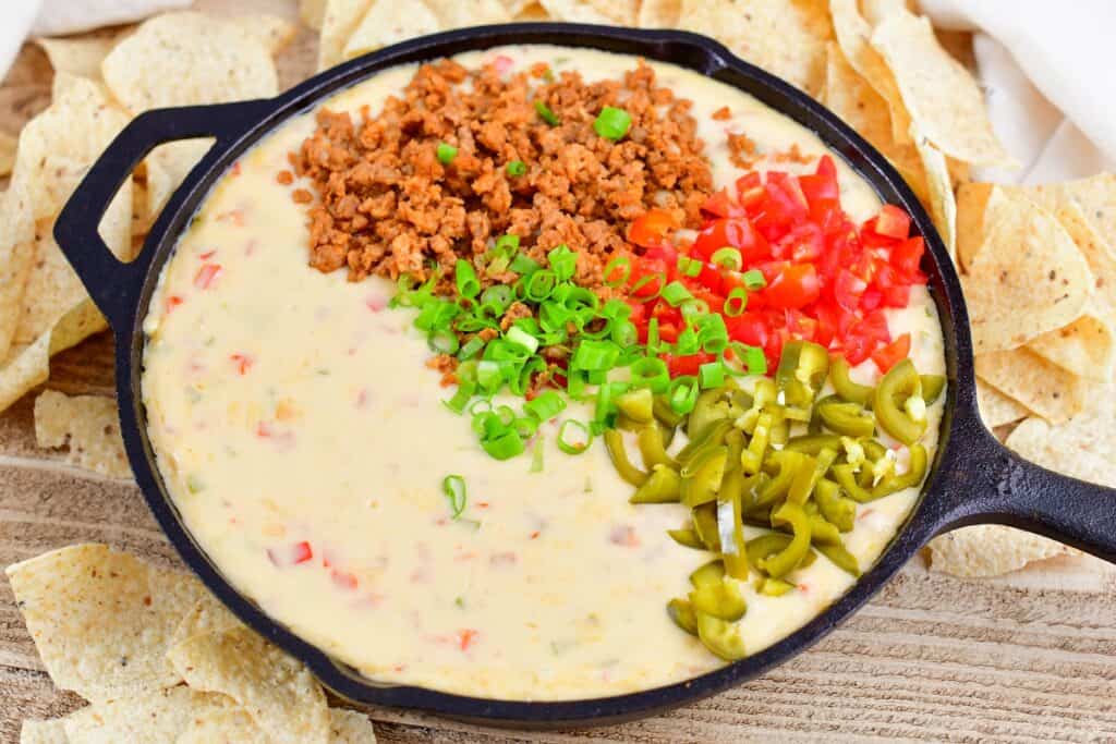 baked queso dip topped with chorizo and veggies
