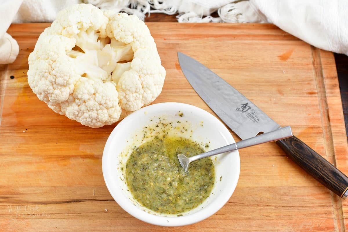 seasoning mixed with oil and cheese and head of cauliflower