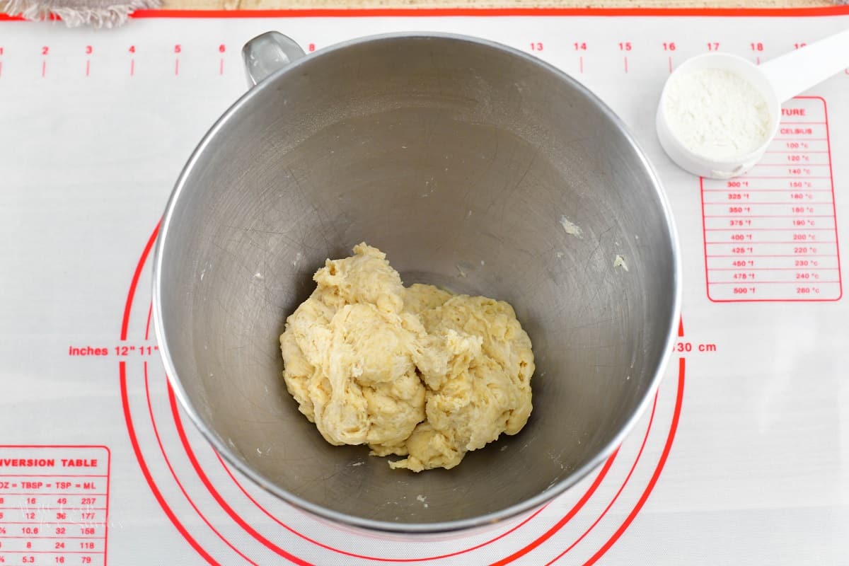 mixed pizza crust dough in the metal bowl