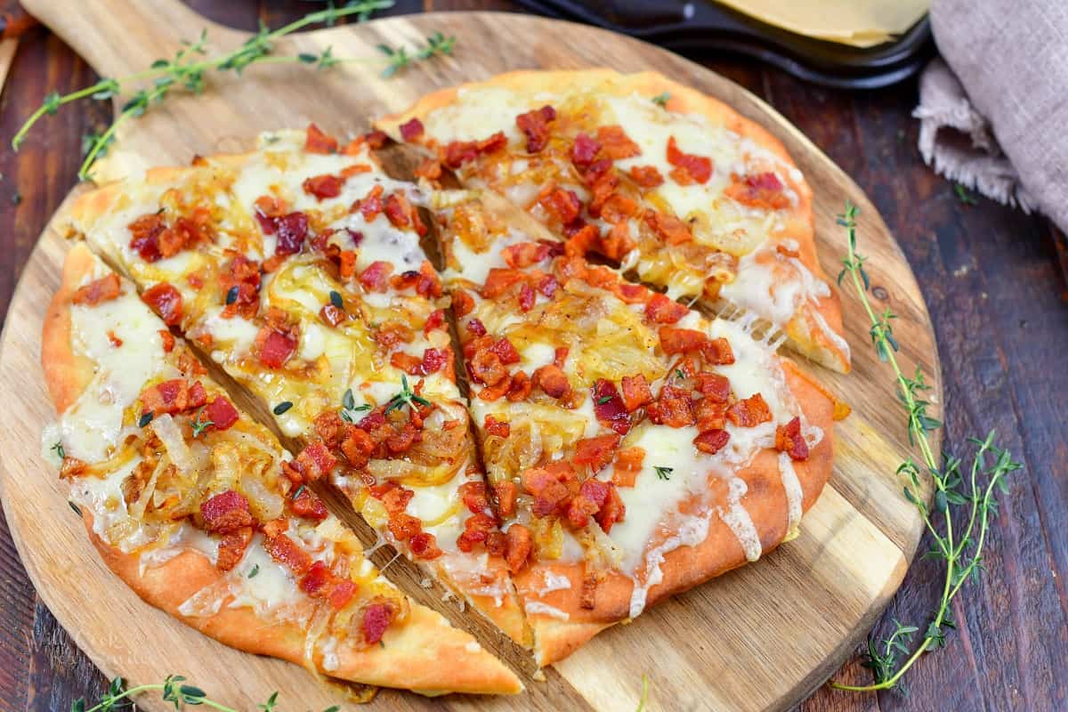 closeup of sliced flatbread pizza with bacon and onion