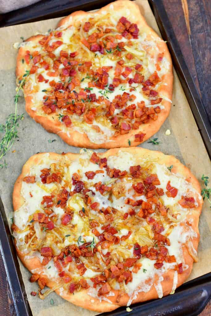 top view of two baked flatbread pizzas on baking sheet