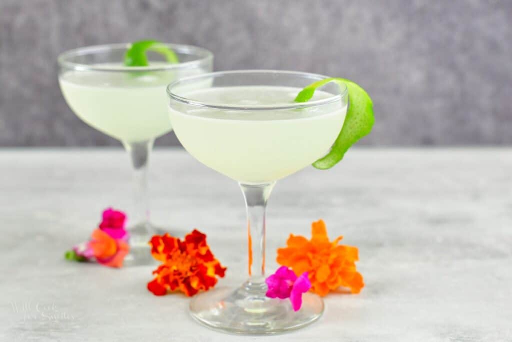 two champagne glasses with daiquiri and flowers around