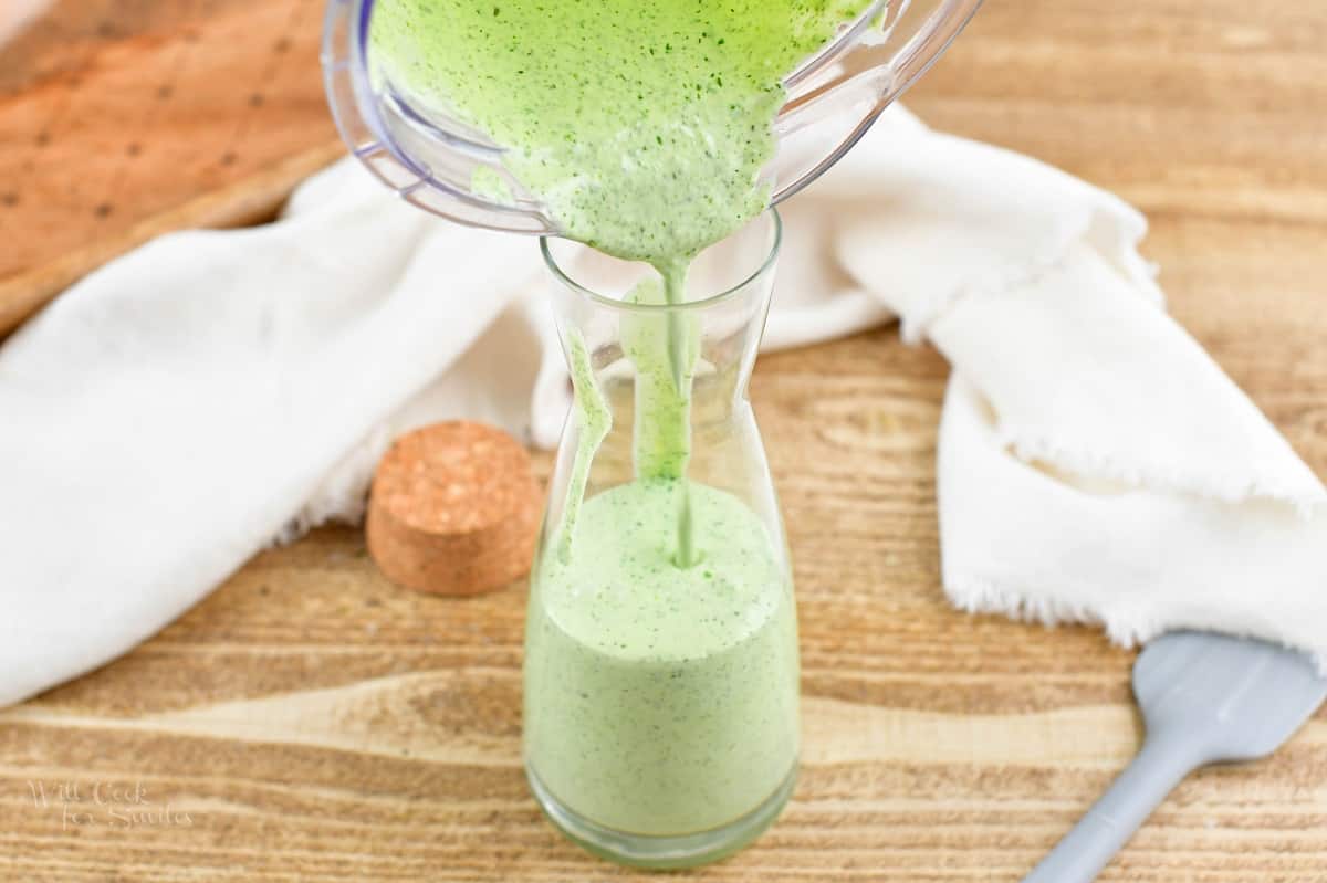 pouring the green goddess dressing into the jar