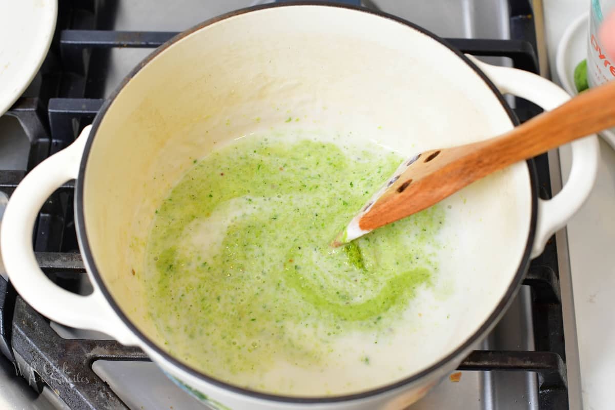 stirring in green curry paste into the coconut milk