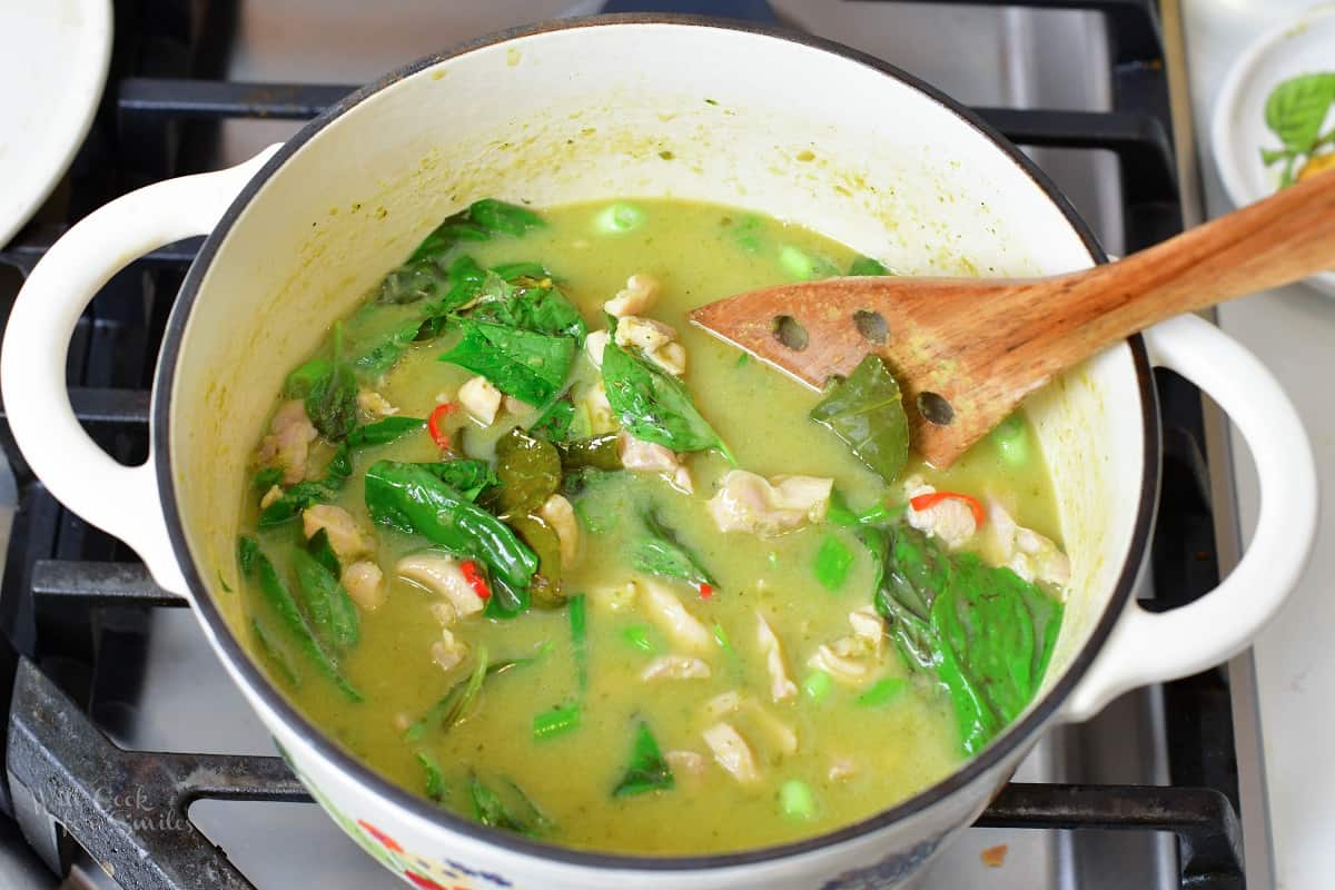 Thai green curry cooking in a white pot