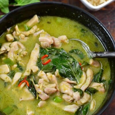 spooning some green curry out of the bowl