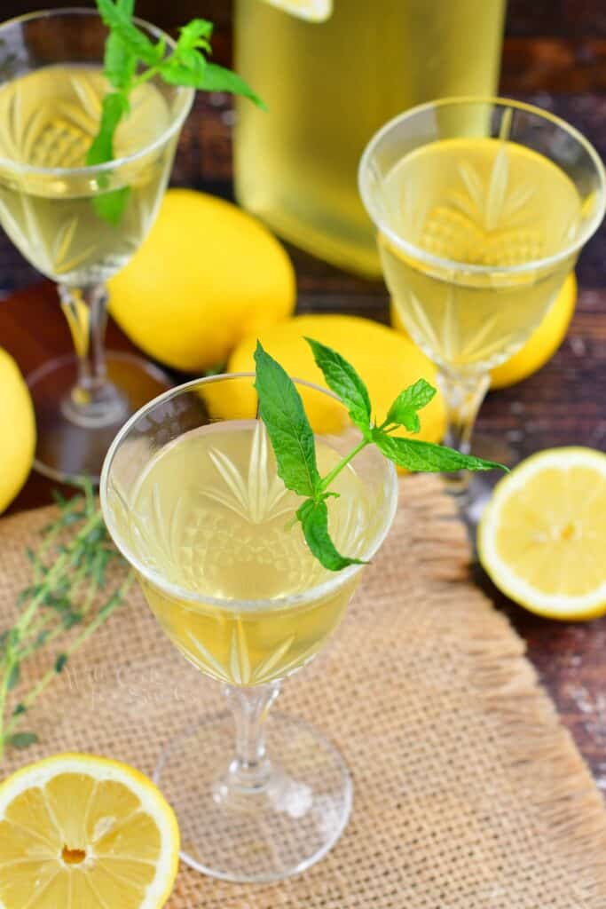 top view of limoncello in glasses with mint and lemons around