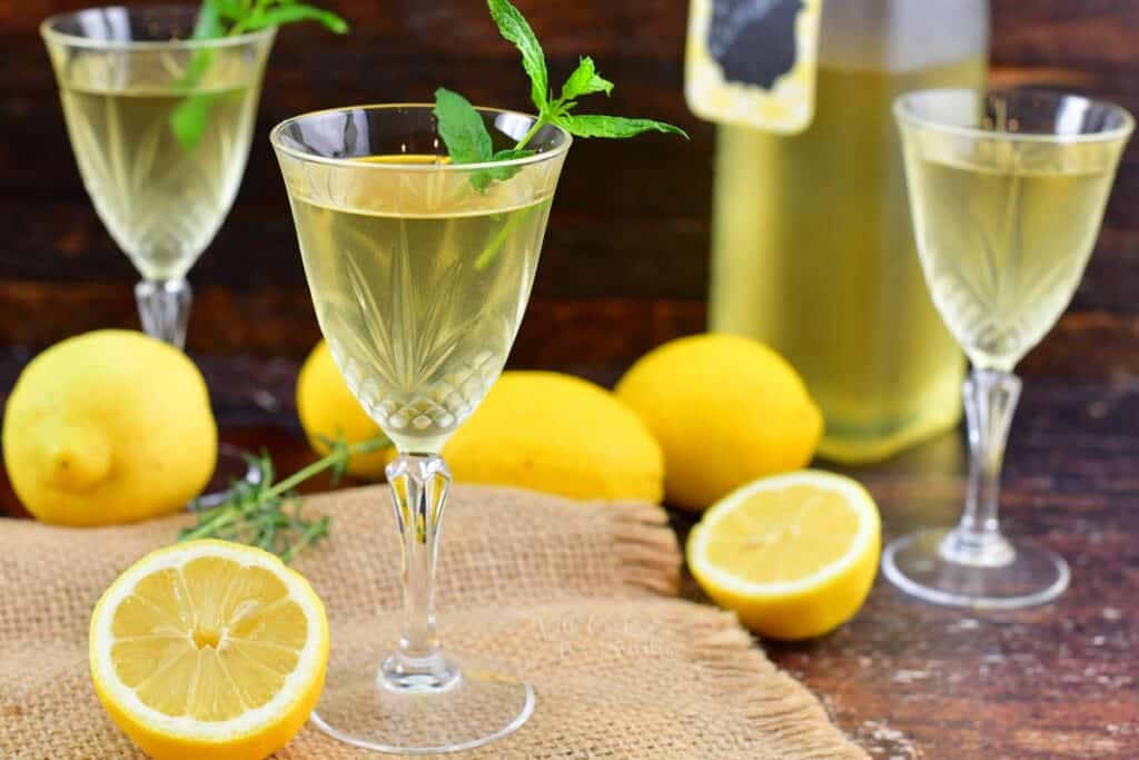 closeup of three glasses filled with lemon liqueur