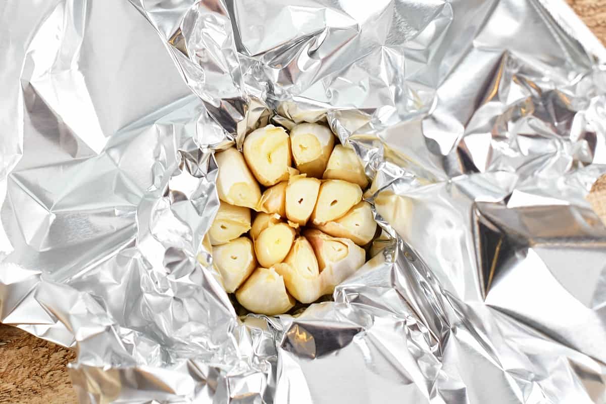 top view of garlic bulb in foil with tip cut off