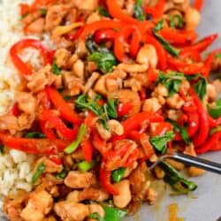 scooping some cooked basil chicken in the plate