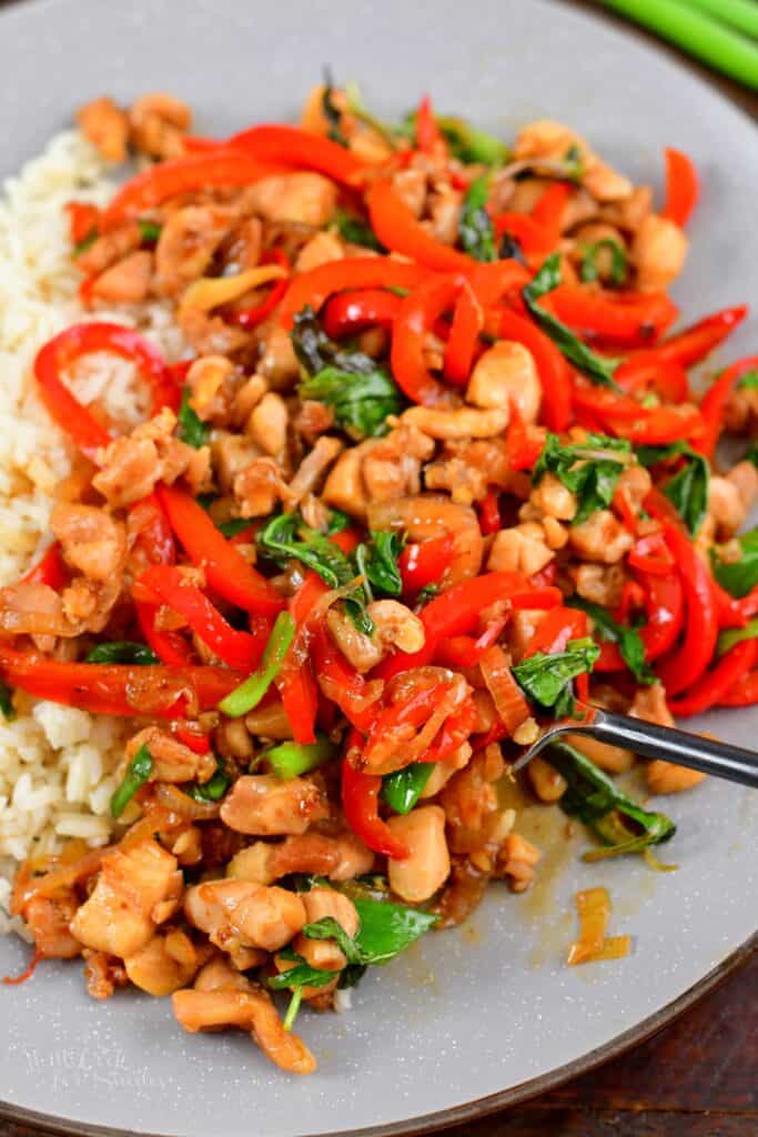 scooping some cooked basil chicken in the plate