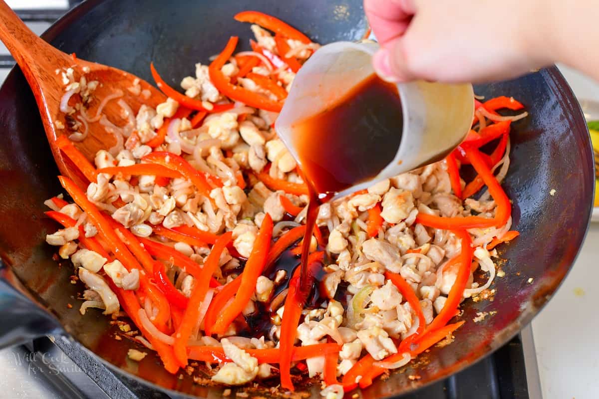 pouring in sauce into chicken and peppers