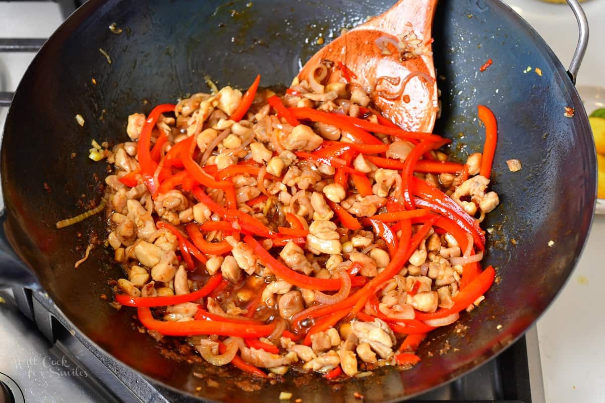 stirring vegetables with chicken in a wok