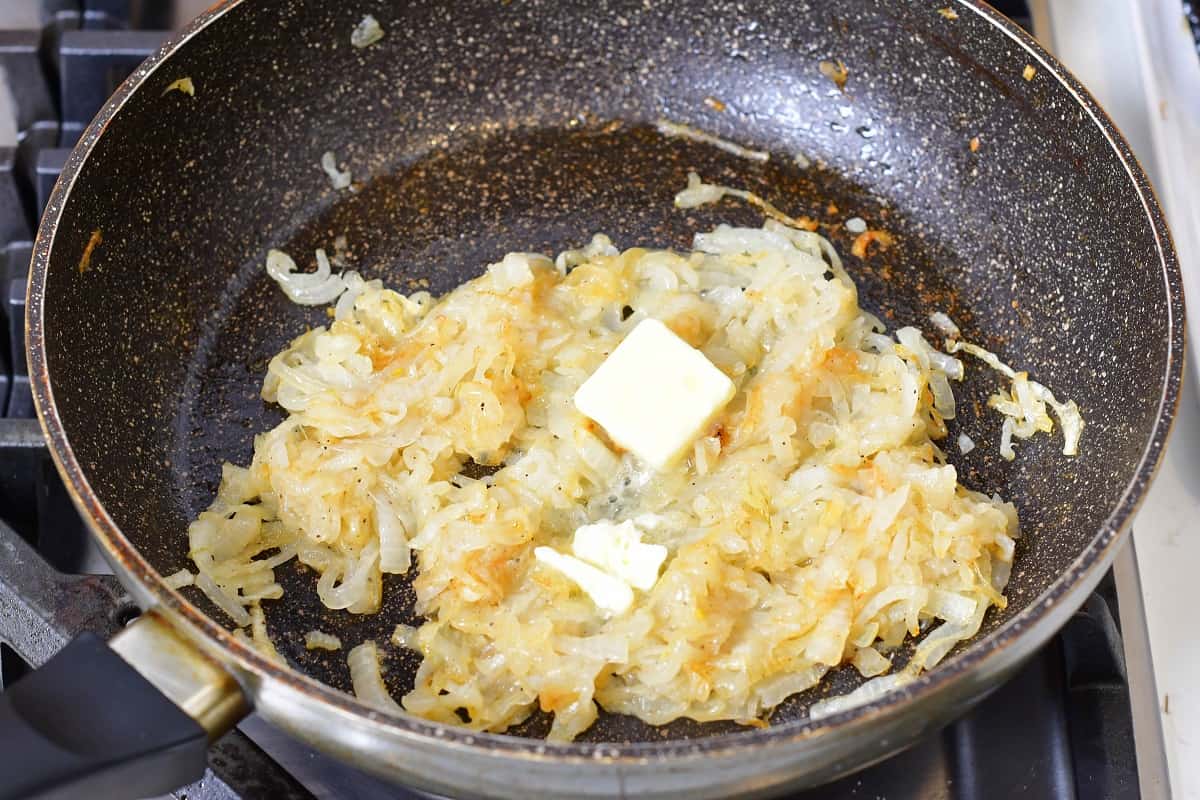 adding butter to onions as they cook