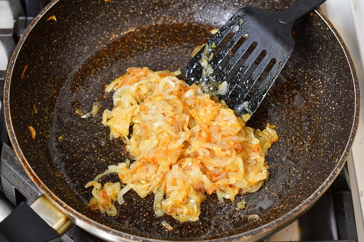 caramelized onions in a cooking pan with spatula