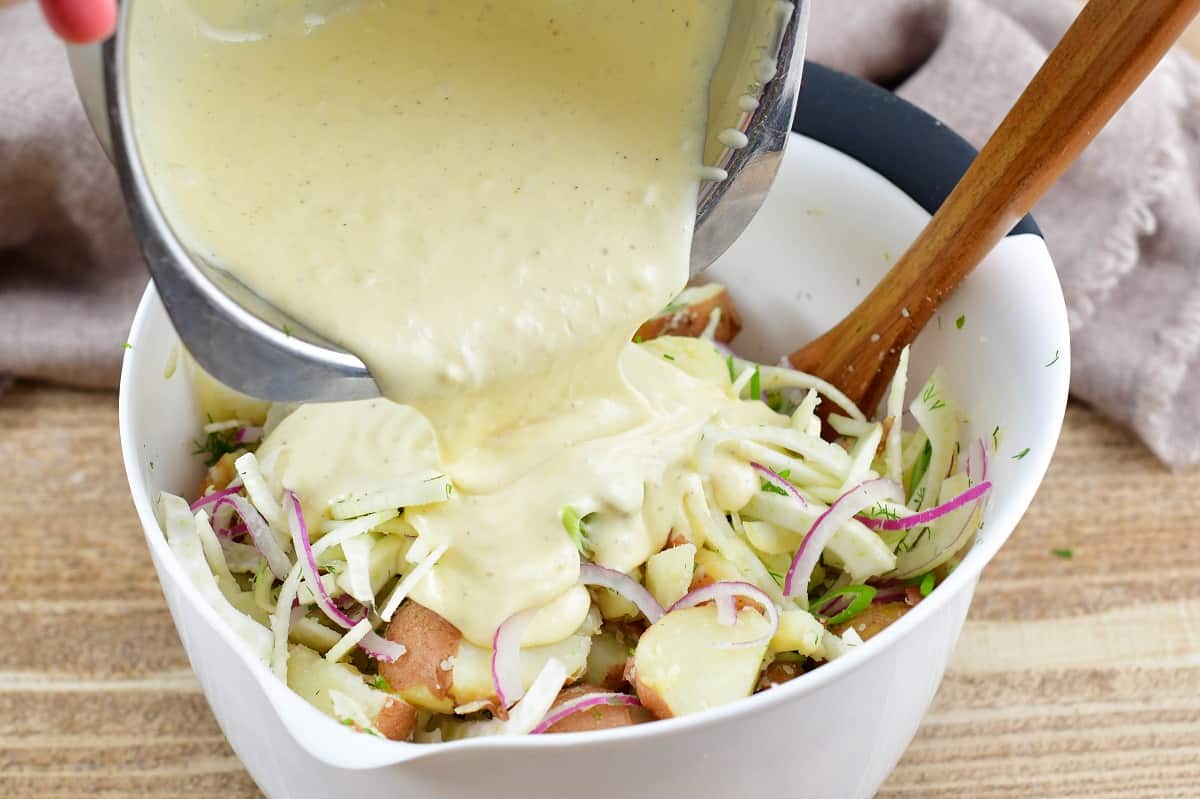 adding the dressing for potato salad into the mixing bowl