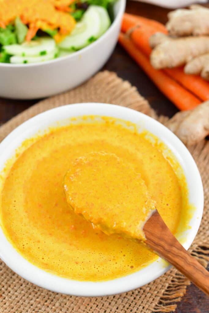 scooping out ginger dressing from a bowl