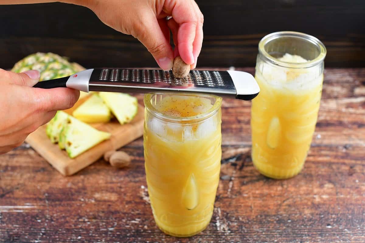 grating nutmeg over the cocktails