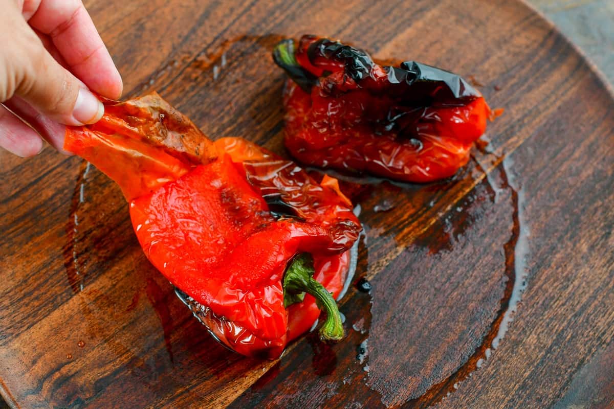 peeling off the skin of roasted peppers