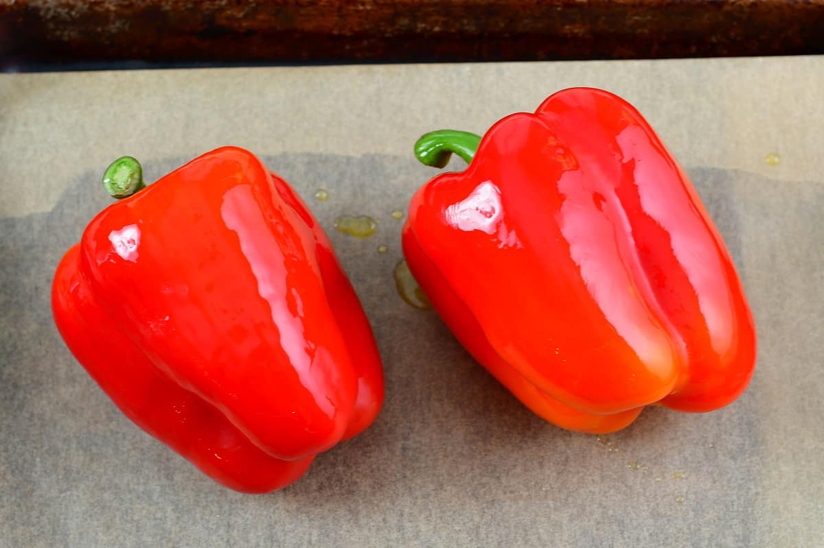 two red bell peppers on the baking sheet before baking