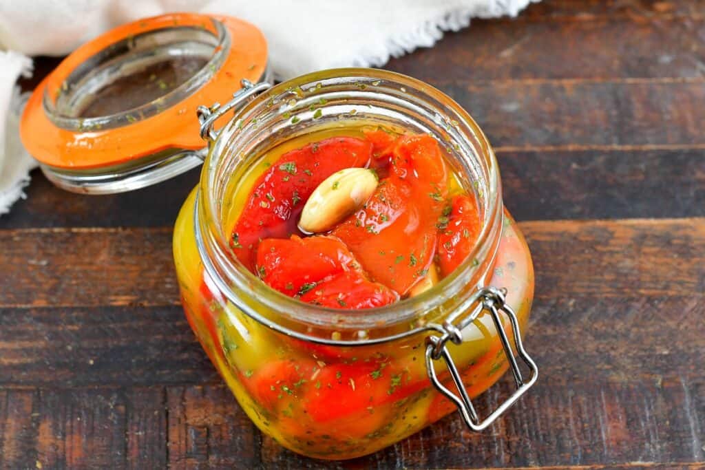 closeup of roasted peppers in oil in a jar