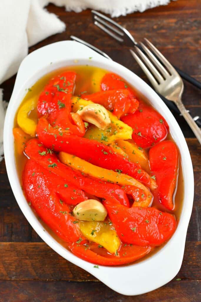 top view of roasted red peppers in oil in a bowl