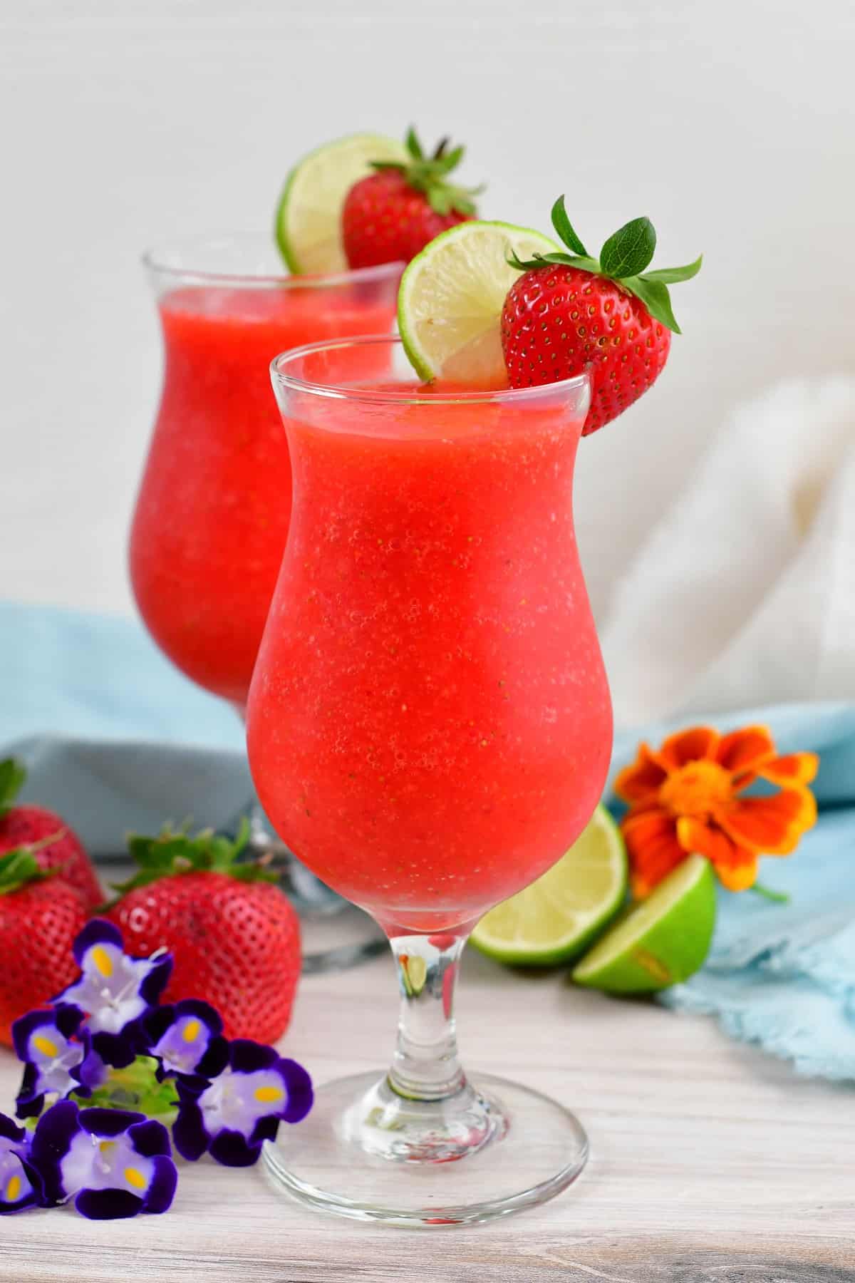 side view of a tall glass filled with red frozen cocktail