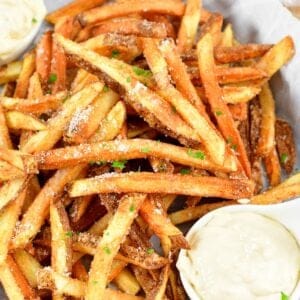 closeup of truffle fries in a basket with aioli