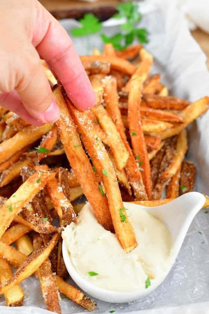 dipping truffle fries into Parmesan aioli