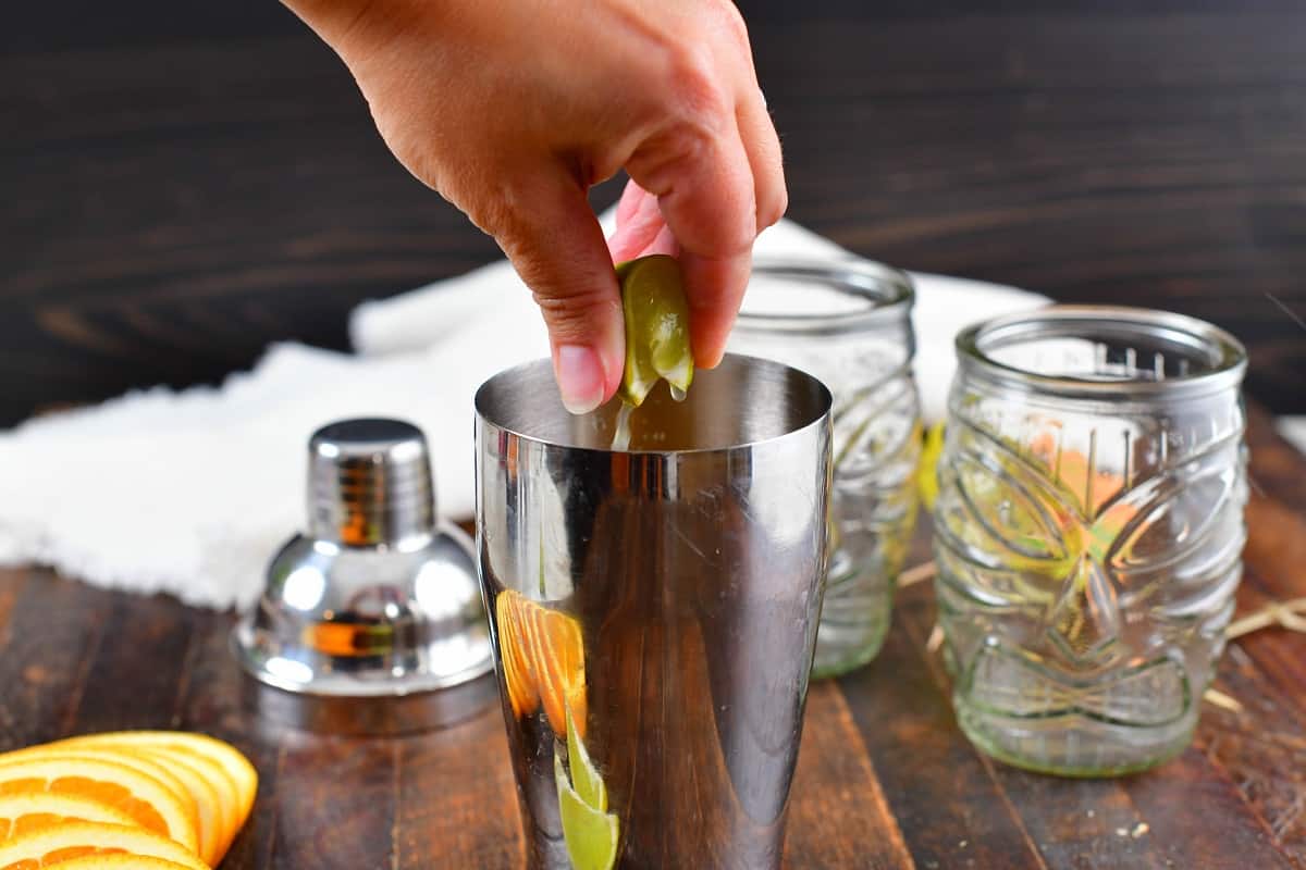 squeezing lime into the cocktail shaker