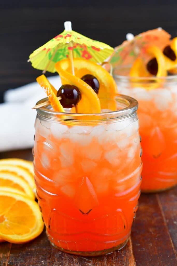 bright orange cocktail in a tiki glass with garnish