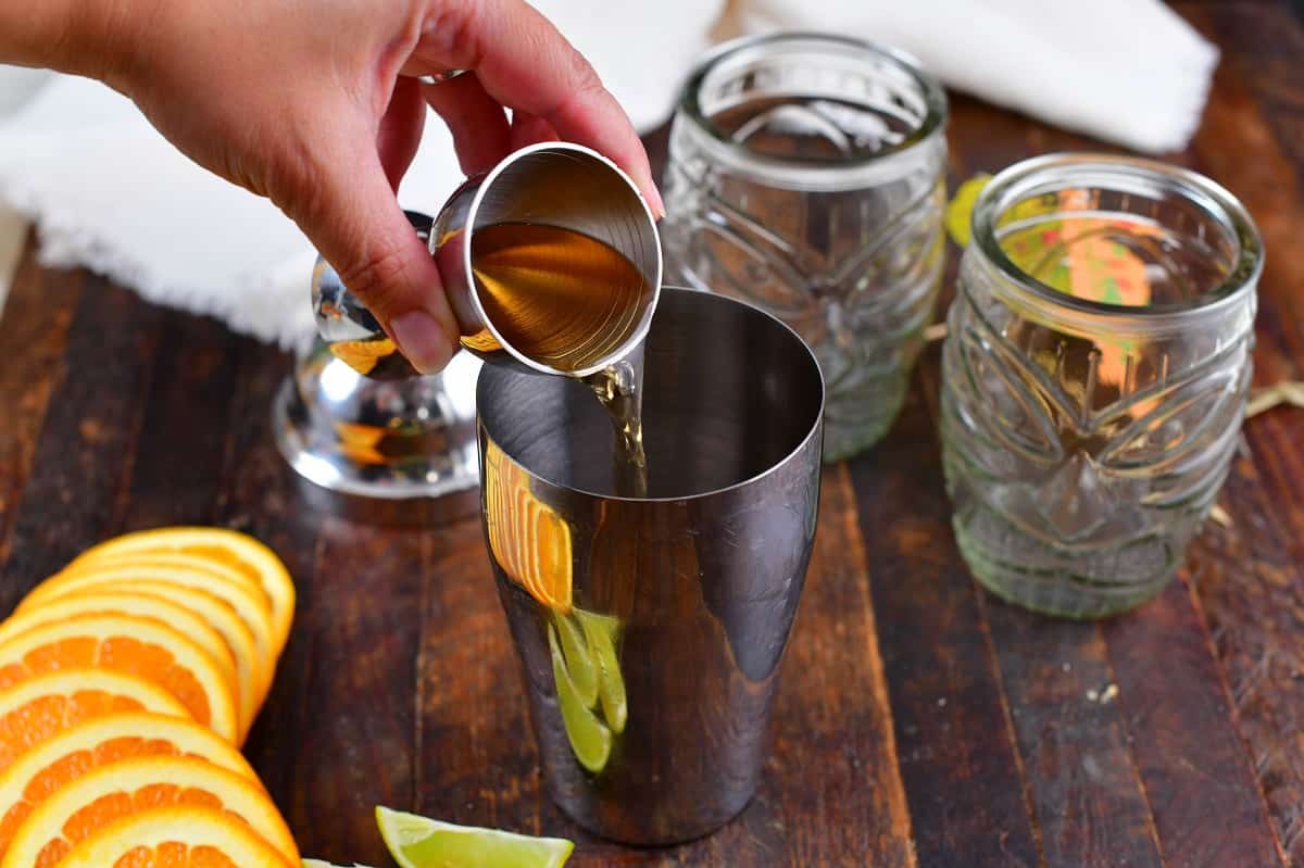 adding peach schnapps into the cocktail shaker