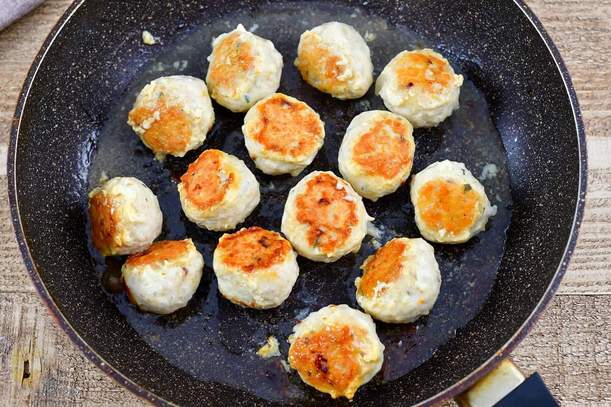 chicken meatballs cooking in a pan