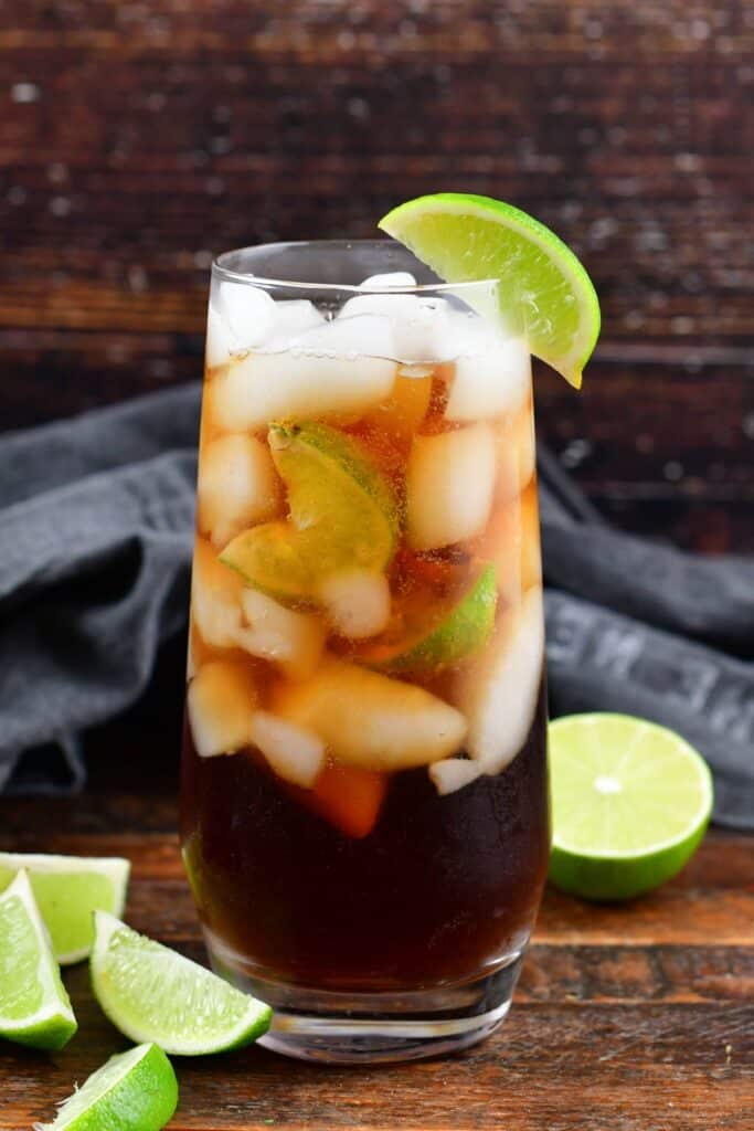 Cuba Libre cocktail with lime in a tall glass