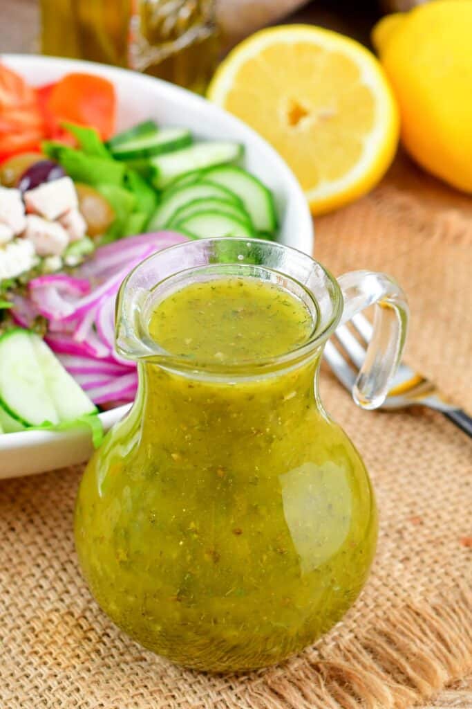 Greek dressing in the glass jar next to salad