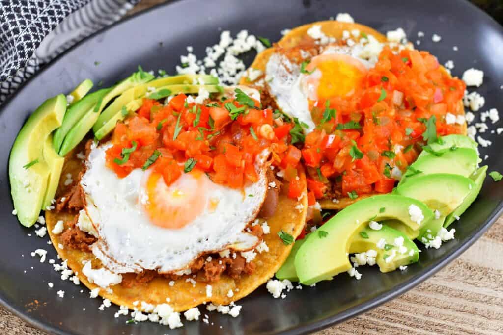 huevos rancheros over beans and tortillas with toppings