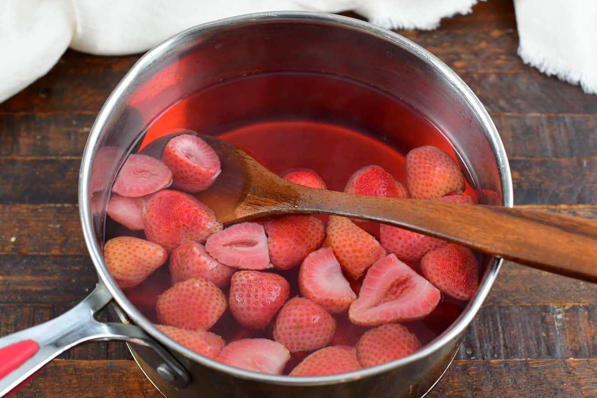 cooked strawberry halves in the pot with water