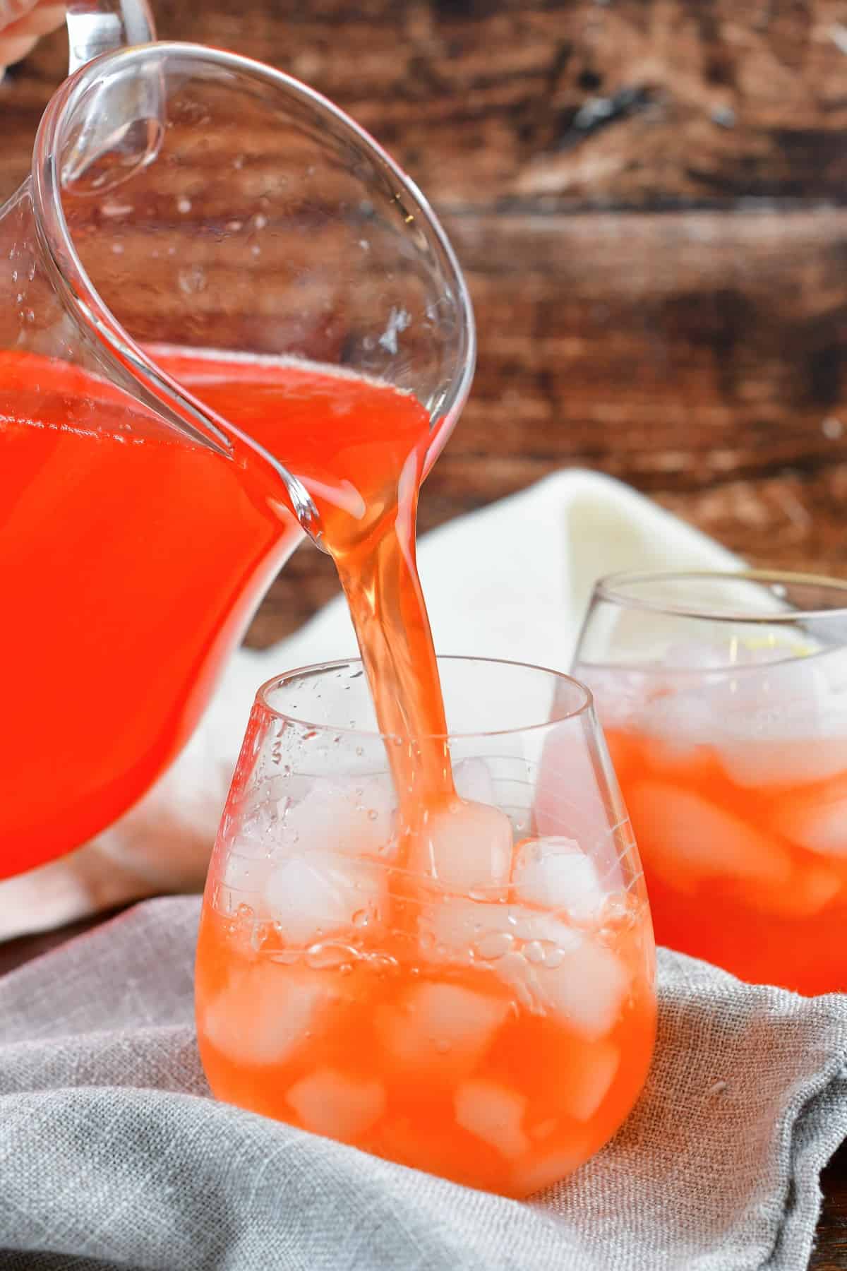 pouring in pink lemonade into the glass