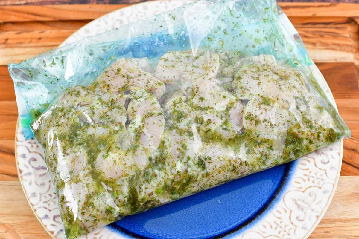 chicken pieces marinating in a Greek marinade in the bag