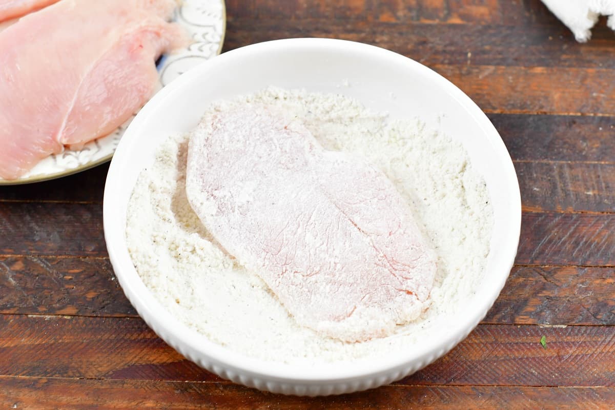 dredging chicken in flour mixture